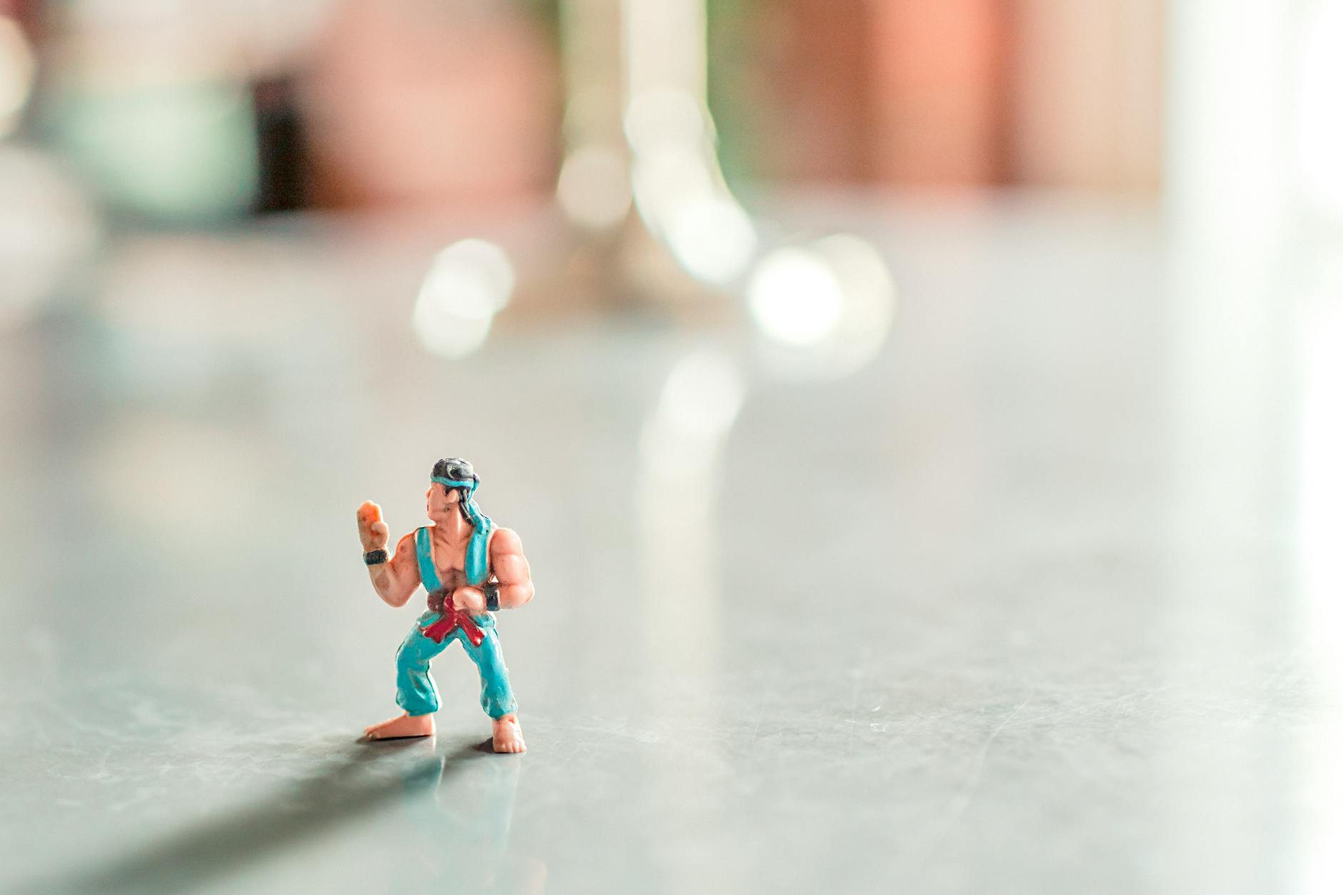 Close-up of a colorful action figure posed on a shiny surface with a blurred background. -- pijushsaha.com
