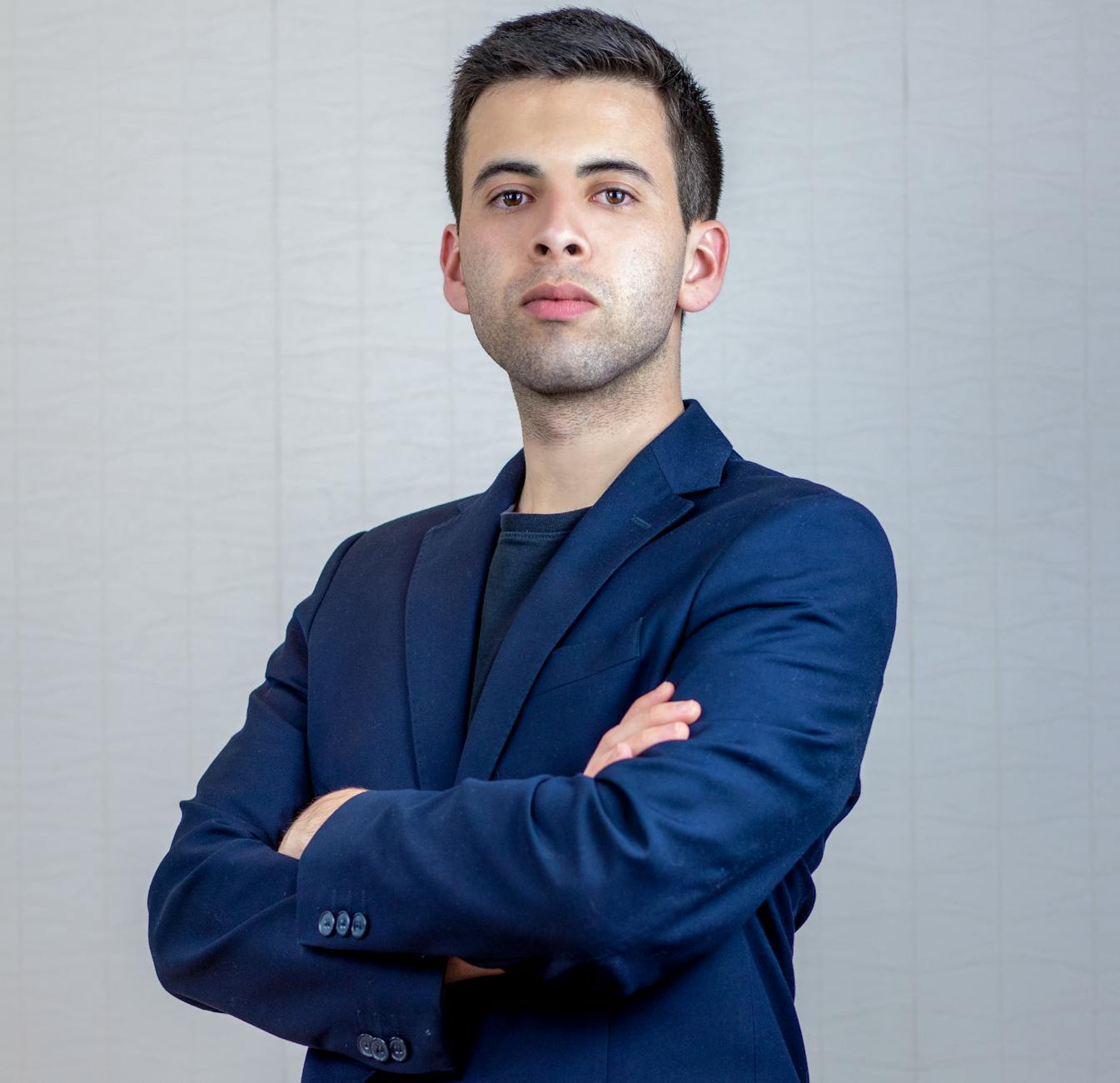 Portrait of a confident businessman in a blue suit with arms crossed, showcasing professionalism. -- pijushsaha.com