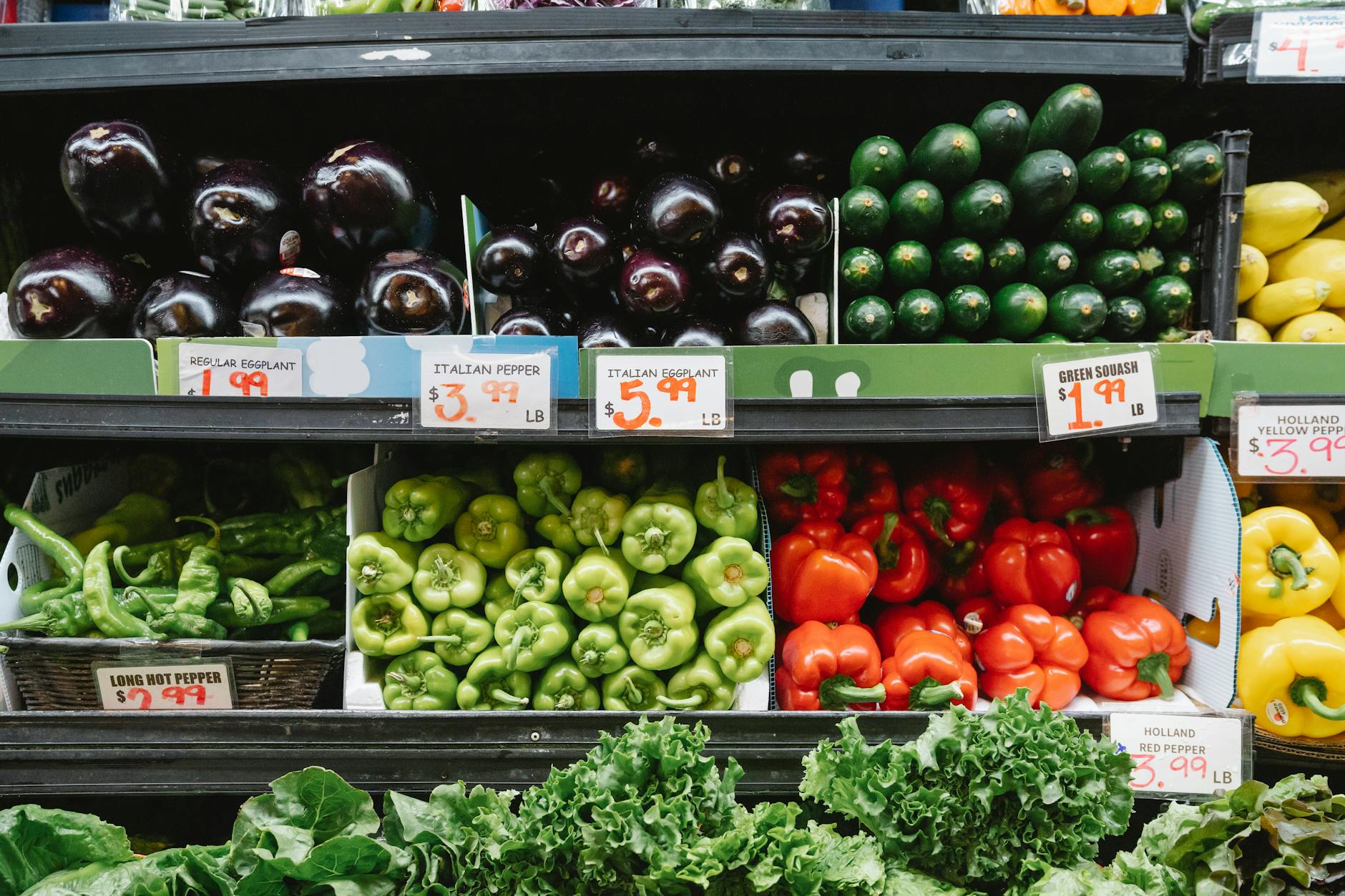 Colorful assortment of vegetables on display in a supermarket, featuring peppers, eggplants, and squash. — pijushsaha.com