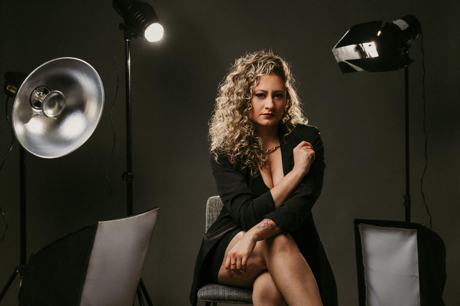 Woman in black blazer poses elegantly in a professional photo studio setting. -- pijushsaha.com