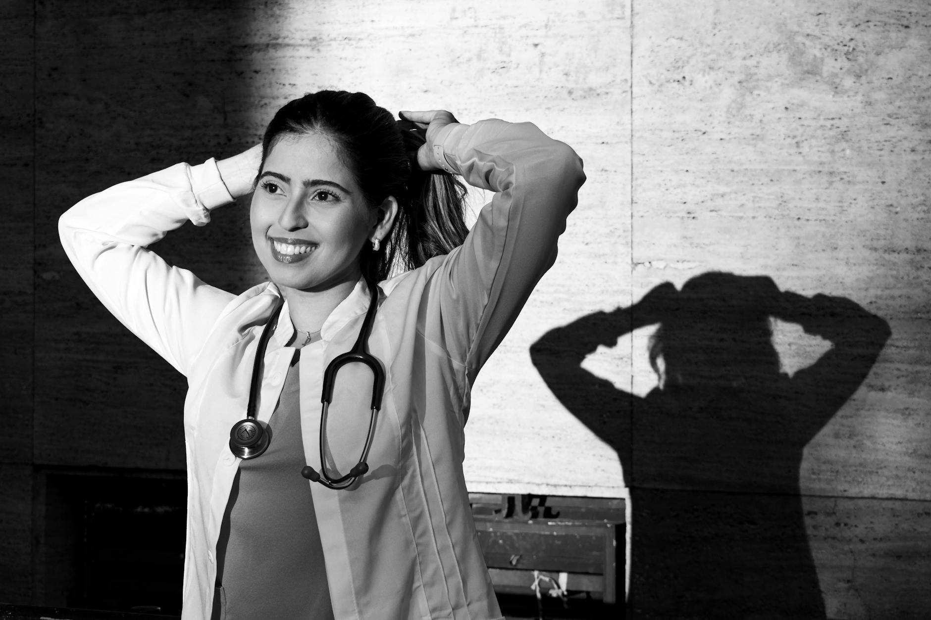 Monochrome portrait of a smiling female doctor with a stethoscope, captured in Buenos Aires. -- pijushsaha.com