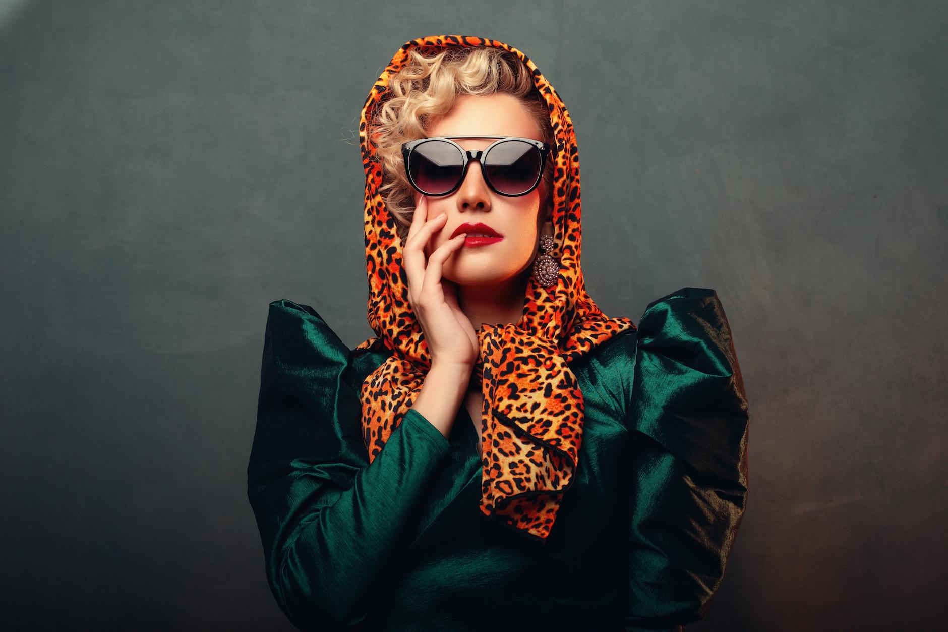 Fashionable woman posing with sunglasses and leopard print headscarf in a dramatic portrait. -- pijushsaha.com