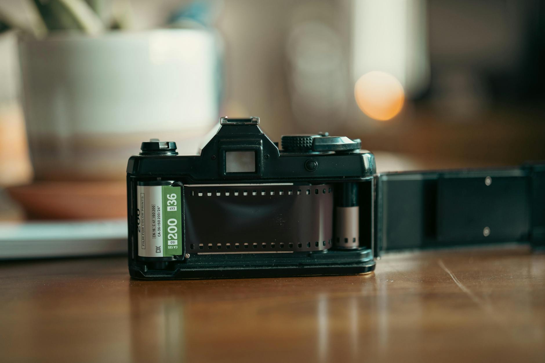 Close-up of an open vintage film camera with film roll inside, captured indoors. -- pijushsaha.com