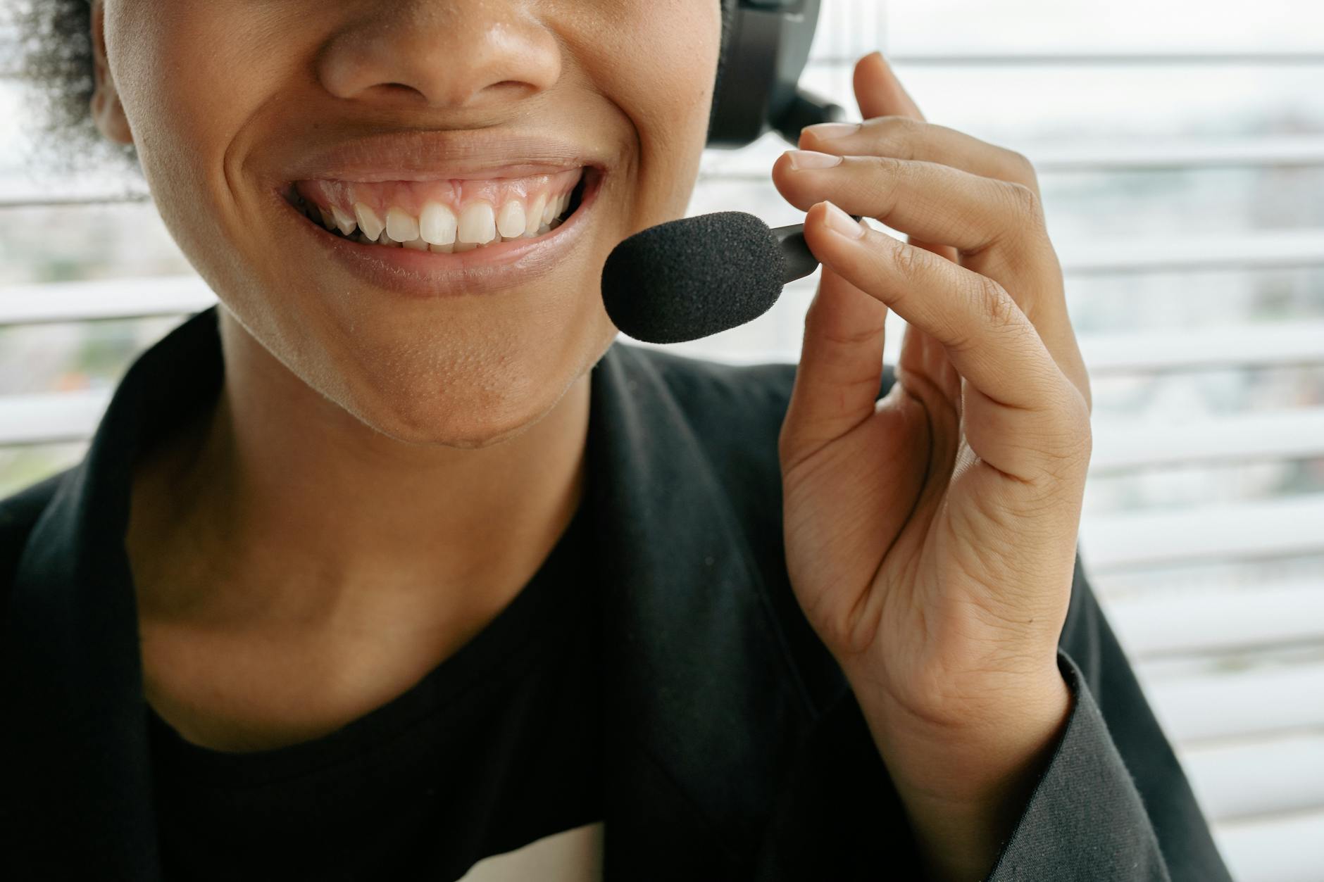 Close-up of a smiling call center representative holding a microphone. — pijushsaha.com