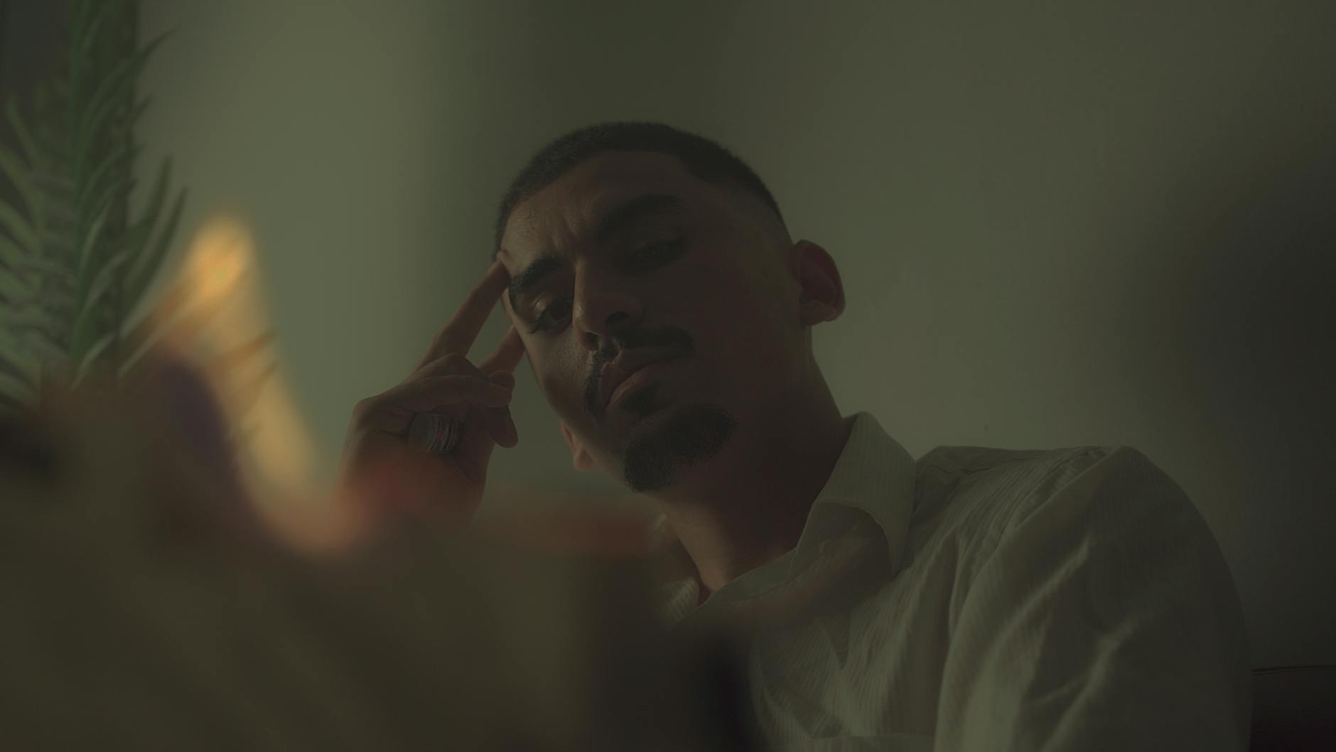 A contemplative man indoors with dramatic, moody lighting and a cinematic feel. -- pijushsaha.com