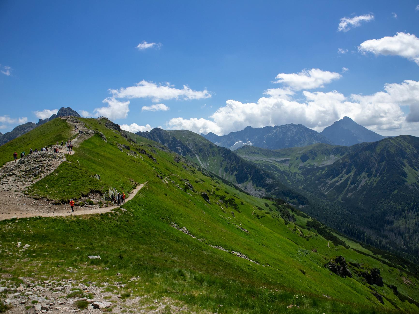 Explore breathtaking views on a hiking trail in Poland's Tatra Mountains under a clear blue sky. -- pijushsaha.com