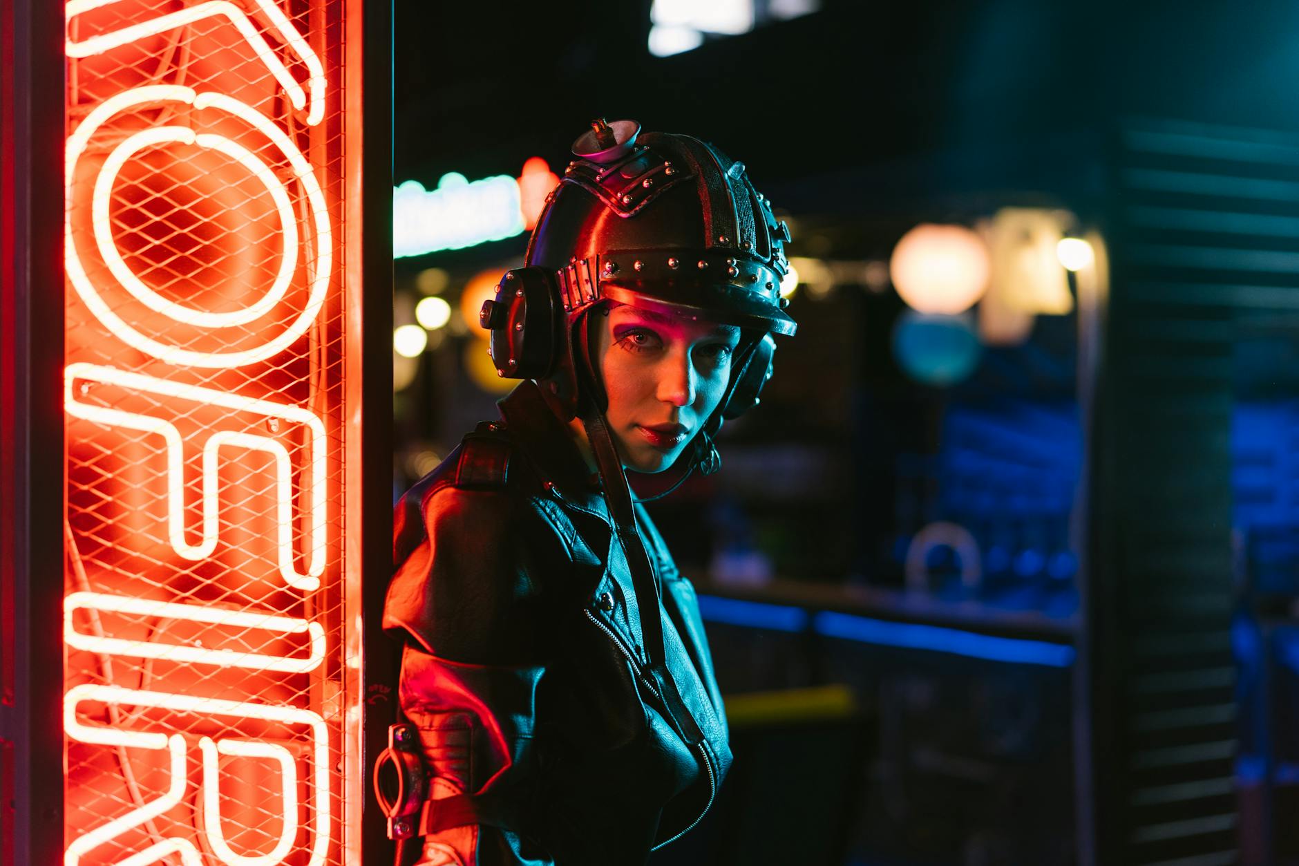 Woman in cyberpunk attire standing by neon sign in an urban setting. -- pijushsaha.com